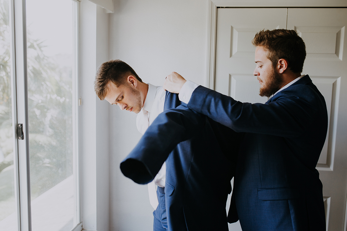 groom getting ready | putting on the suit jacket | groom and best man